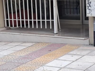 αντικείμενο σφηνωμένο στο πεζοδρόμιο στην  Αδ. Κοραή